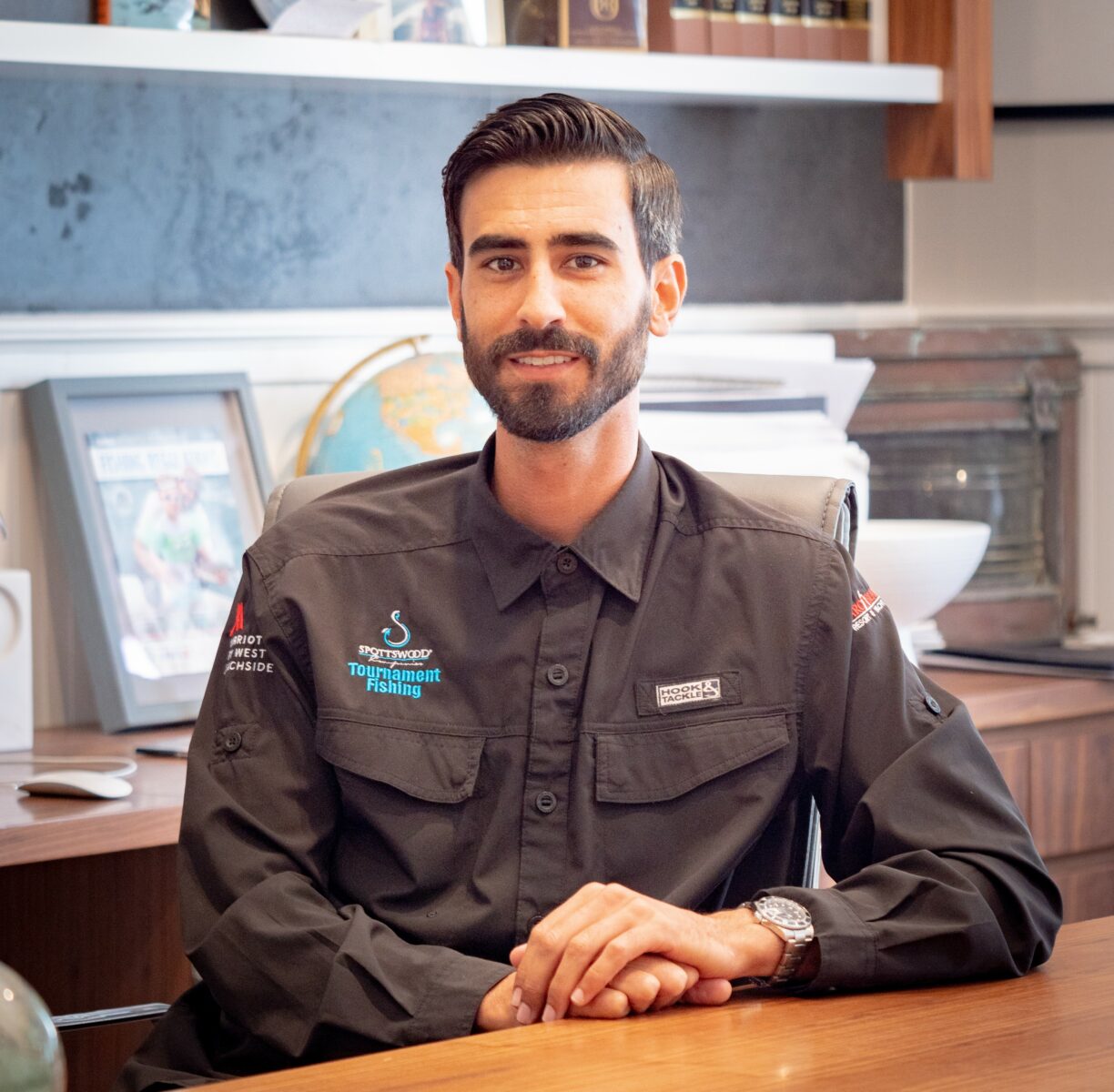 Florida Council Member, Robert Spotswood Jr. sits at his desk with a black collared shirt.