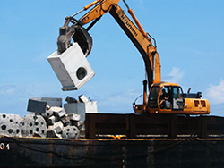 Machinery lifts an artificial reef structure off of a barge. 